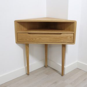Corner nightstand with shelf and lower drawer in solid Oak or Walnut.